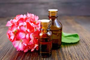 fragrance oil bottles next to a geranium flower